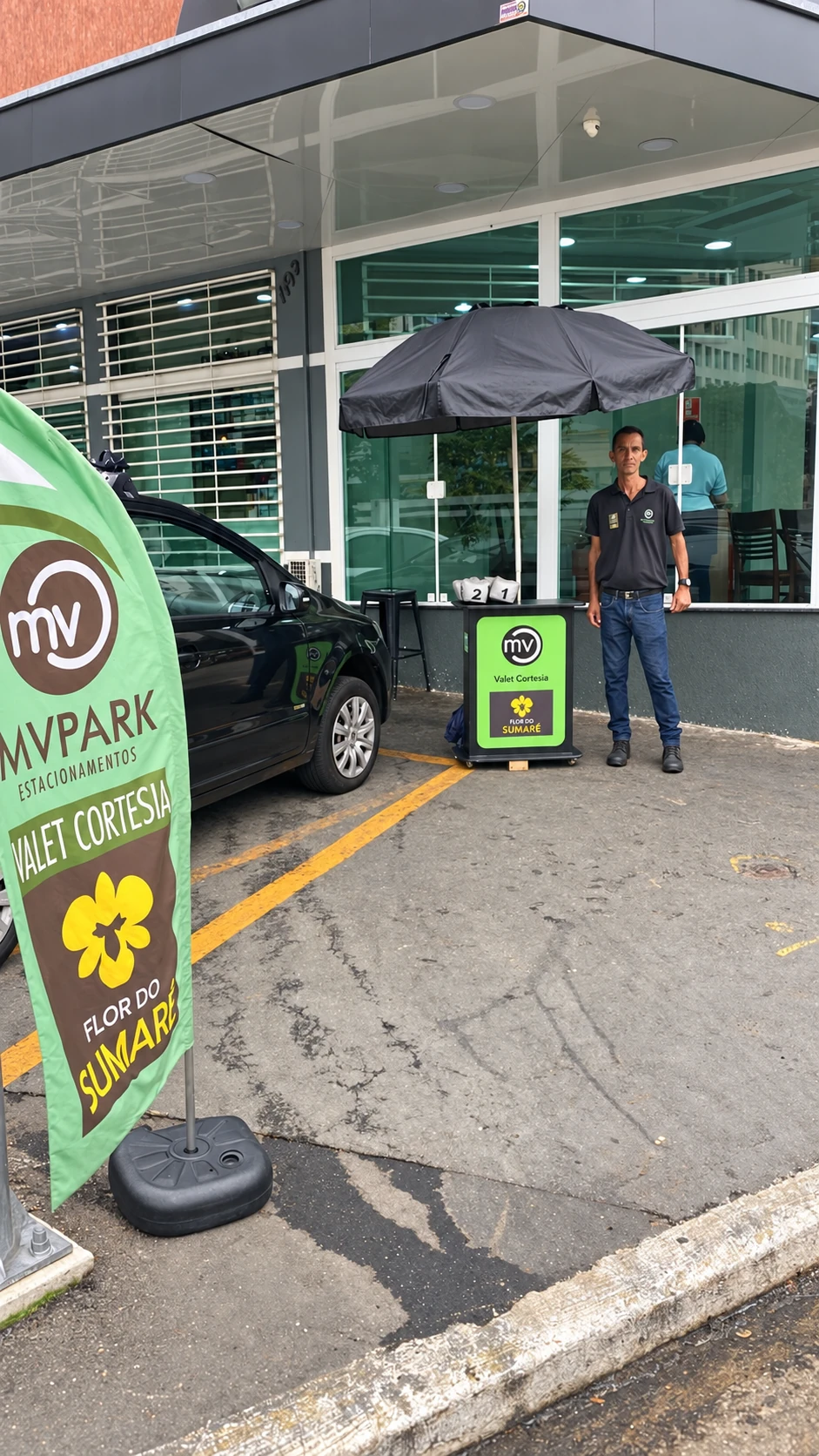 Profissional da MV Park uniformizado ao lado do ponto de recepção
